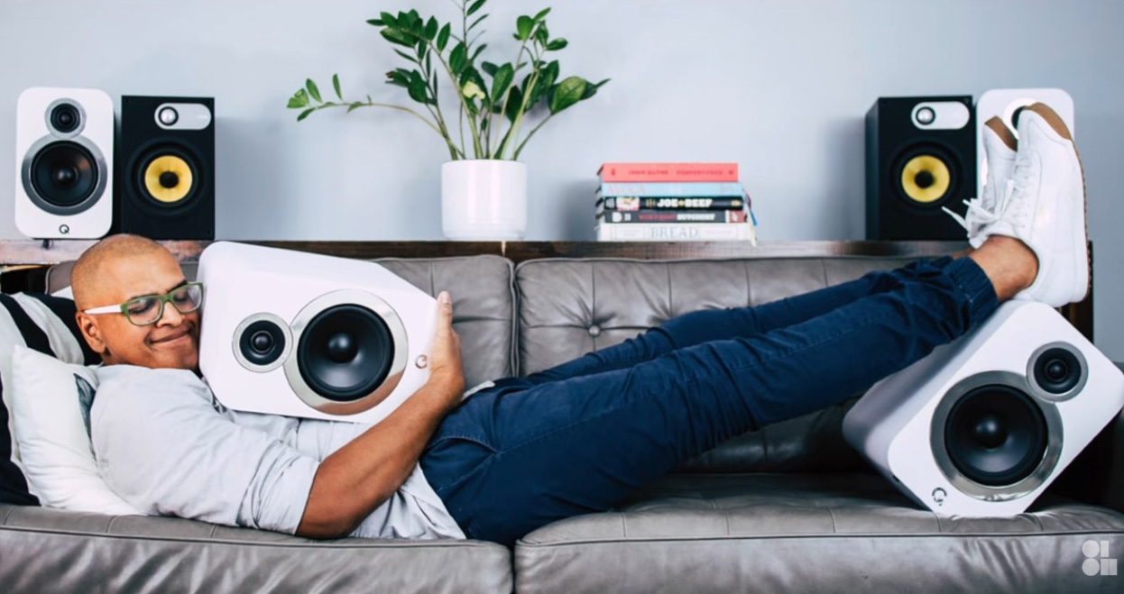 Taps Das on his couch hugging a Q Acoustics 3030c speaker